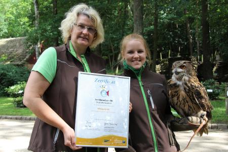 Marketing-Leiterin Maren Gläser und die Auszubildende Gina Motschnek mit Uhu Berta präsentieren stolz die Neuzertifizierung „Familienurlaub MV – Geprüfte Qualität“ des TMV, Foto: Wildpark-MV