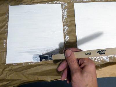 Dünne Holzplatten, weiß matt wie die Rahmen lackiert, ersetzen die eingeschobenen Plexiglasscheiben, damit Ständer für Werbeflyer angebracht werden können.