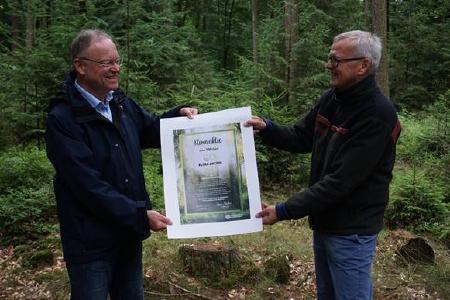 Schirmherr der Klima-Aktion Wald, Ministerpräsident Stephan Weil, nimmt die erste Klima-Aktie von Dr. Klaus Merker, Präsident der Niedersächsischen Landesforsten, entgegen