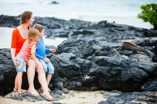 Mother and kids looking at endemic marine iguana at Galapagos islands, shutterstock_1278839.jpg