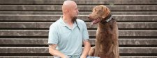 Hund und Besitzer schauen sich gegenseitig an.