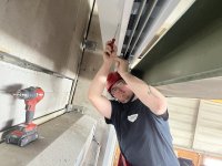 Moritz bei der Arbeit an einer Lüftungsanlage bei einem Rolltor in der Fertighausproduktionshalle bei Schwörer Haus.