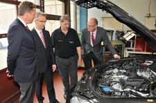 Matthias Willy und Mark Hüttenberger von der Daimler-Niederlassung Reutlingen-Tübingen, Ausbildungsmeister Norbert Krauß und Dr. Joachim Eisert werfen einen Blick in den Motorraum des neuen Übungsobjekts, Foto: Handwerkskammer
