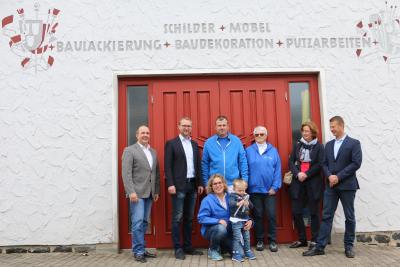 Abschlussfoto vor dem schmucken Werkstatttor: In der Mitte Familie Lerch (vorne Iris und Leo, dahinter Torsten und dessen Mutter Ellen), links davon Wirtschaftsdezernent Dr. Jens Mischak und Matthias Steckenreuter (Vogelsberg Consult GmbH), rechts Andrea Ortstadt (Wirtschaftsförderung Vogelsbergkreis) und Bürgermeister Timo Georg. Fotos: Gaby Richter, Vogelsbergkreis