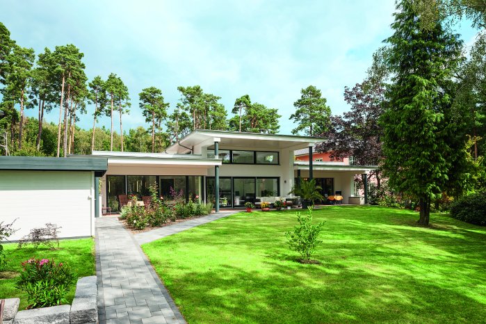 Harmonisch eingebettet in die umgebenden Bäume, bietet der Bungalow insgesamt 239 m² Wohnfl.tif