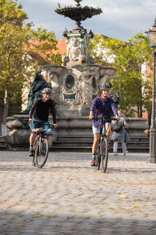 Radfahren mit Paulibrunnen im Hintergrund (c) Gideon Heede.jpg