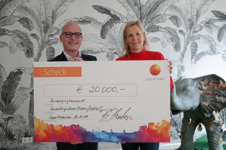 Jérôme Kuzio, Head of Marketing DACH bei CooperVision übergibt den Spendenscheck in Höhe von 20.000€ an Monika König, Vorsitzende des Kuratoriums und Gründerin der KinderAugenKrebsStiftung KAKS