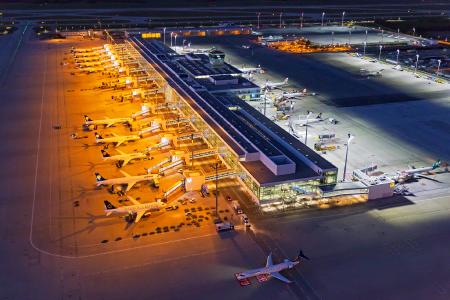 Die gesamte Vorfeldbeleuchtung am Flughafen München ist nun auf energiesparende LED-Technik umgestellt. Das Foto zeigt die alte und die neue Beleuchtungstechnik: Während die alten Natriumdampflampen (links im Bild) gelblich leuchten, geben die neuen LEDs ein strahlend weißes Licht ab (rechts im Bild). Die neue Technik wirkt bei gleicher Lichtleistung wesentlich heller und verbraucht deutlich weniger Energie