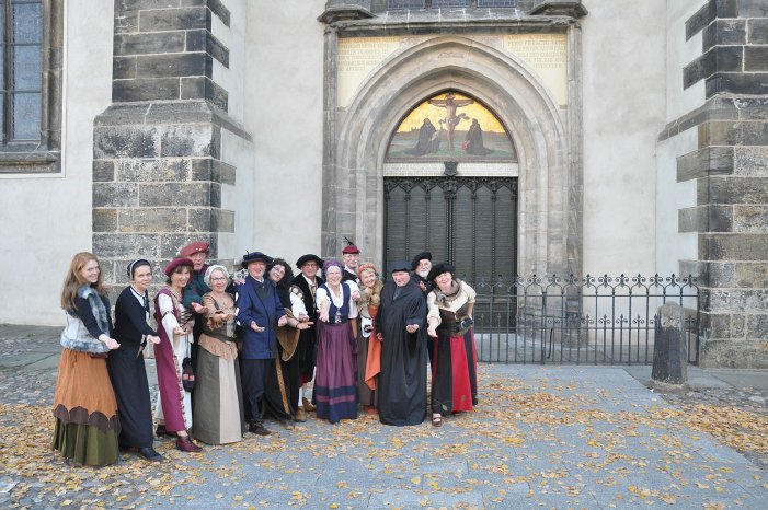 Herzlich willkommen in Lutherstadt Wittenber_Stadtführer begrüßen Gäste vor der Thesentür© Touri.JPG