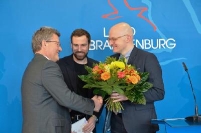 Thomas Kralinski (r.), Chef der Potsdamer Staatskanzlei, beglückwünscht Oculyze-Geschäftsführer Kilian Moser und Team-Berater Prof. Dr. Marcus Frohme (l.) zur Auszeichnung