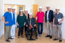  Prof. Sascha Meyer, Alfred Leipold, Oberarzt auf der Station S24, Admira Knoll, Yvonne Haßler, Pflegedienstleitung im Zentrum für Kinder und Frauen, Andreas „Joker“ Jopp, Peter Knoll, Vorsitzender der FUoKK Stiftung, Markus Heming und Dipl.-Ing. Stefan Eller (v.l.n.r.) auf der S24, wo bereits das erste Gerät eingebaut wurde