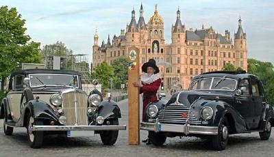 Zwei Oldtimer (Horch und EMW) vor dem Schweriner Schloss mit Mann in historischer Uniform