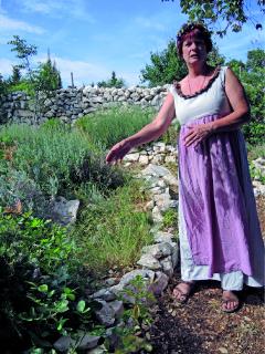 Pensionswirtin Sonja pflanzt im Kräutergarten Salbei und andere Kräuter an.