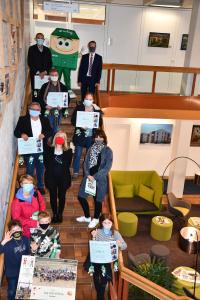 Gruppenbild auf der Treppe der wbg Unternehmenszentrale mit Abstand und Maskottchen Hausi. Foto: Carolin Weigand