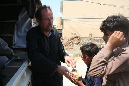 Shelter Now-Direktor Udo Stolte bei der Verteilung von Essensrationen an Flutopfer in Pakistan