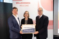 Landwirtschaftsminister Werner Schwarz (r.) überreicht Vizepräsidentin für Forschung und Internationales, Karen Cabos (m.) und Professor Maximilian Schüler der TH Lübeck einen Förderbescheid. Foto: TH Lübeck 