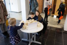 Die Geschwister Jul und Tilda Kaddour sind regelmäßig als junge Forscher beim JuniorCampus unterwegs. Hier probieren sie die Station „Hörmemory“ aus, bei der die Kinder die Geräusche von Salz, Sand und Kieselsteinen in Holzwürfeln ernennen und zwei zusammengehörende Paare finden müssen. Foto: TH Lübeck