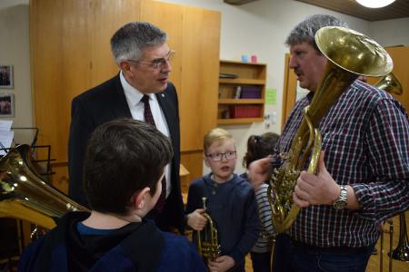 Thomas Borrmann (rechts) erläutert, was sich bei Blechblasinstrumenten und den musikalischen Anforderungen in den Jahrzehnten des Bestehens des Posaunenchores verändert hat. (Foto: Vogelsbergkreis / Christian Lips)