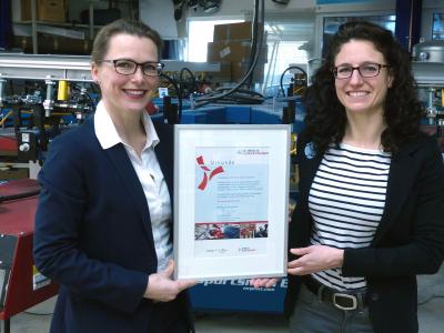 Dr. Diana Wehlau, Referatsleiterin Umweltinnovationen & Anpassung an den Klimawandel beim Senator für Umwelt, Bau und Verkehr, gratuliert Inhaberin Sylvia Heißenhuber zur Auszeichnung „Klimaschutzbetrieb CO2 minus 20“. Das Unternehmen konnte seinen CO2-Ausstoß um mehr als 20 Prozent senken.