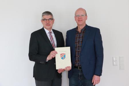 Jürgen Henke ist Bautechniker und seit 25 Jahren als technischer Angestellter im Amt für Schulen und Liegenschaften beschäftigt. Landrat Görig gratulierte zum Dienstjubiläum. Foto: Gaby Richter
