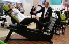 Ein Mitarbeiter von HUR erklärt einem Sportarzt wie die neue Beinpresse auch für das Training von Sprungtechniken eingesetzt werden kann.