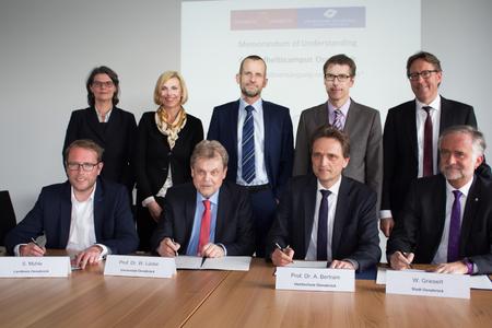 Prof. Dr. Birgit Babitsch (hintere Reihe, links) und Prof. Dr. Andrea Braun von Reinersdorff stellten die Idee des Gesundheitscampus Osnabrück vor. Im Anschluss unterzeichneten die Kooperationspartner das Memorandum of Understanding: (vorne, von links) Stefan Muhle, Erster Kreisrat, Prof. Dr. Wolfgang Lücke, Präsident der Universität Osnabrück, Prof. Dr. Andreas Bertram, Präsident der Hochschule Osnabrück, Wolfgang Griesert, Oberbürgermeister Osnabrücks, sowie (stehend, von rechts) Dr. Michael Böckelmann, erster Vorsitzender von GewiNet und Geschäftsführer der Schüchtermann-Klinik Bad Rothenfelde, Friedemann Pannen, Superintendent Evangelisch-lutherischer Kirchenkreis, und Dr. Bernd Runde, Niels-Stensen-Kliniken GmbH für das Generalvikariat des Bistums Osnabrück