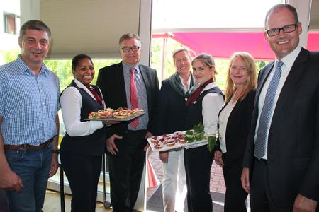 Jürgen Hansen, Geschäftsführer von pro regio e.V. (von links), Fermina de los Santos-Heidler, Auszubildende, Regionspräsident Hauke Jagau, Ulrike Hornig, Geschäftsleitung des Hotels VIVA CREATIVO, Joana Mendes de Jesus, Auszubildende, Uta Wadehn-Czechan, Geschäftsleitung des Hotels VIVA CREATIVO, und Ulf-Birger Franz, Dezernent für Bildung, Wirtschaft und Verkehr werben für weitere Ausbildungsplätze