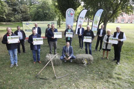 Die stolzen Preisträger aus dem Vogelsberg in Wiesbaden: Die Erstplatzierten und der Gewinner des Sonderpreises der 3. Bergmähwiesen-Meisterschaft im Vogelsberg erhalten von Umweltstaatssekretär Oliver Conz die Preise. Auch Vertreter des Vogelsbergkreises, dessen Amt für Wirtschaft und den ländlichen Raum den Wettbewerb ausrichtet, des Naturschutzgroßprojekts Vogelsberg, der Initiative „Nähe ist gut“ und der Partnerunternehmen gratulieren zum Gewinn. (Foto: Nähe ist gut)