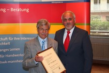 Kammerpräsident Walter Tschischka (rechts) gratuliert Karl-Heinz Rohrmann (links) zur Ehrennadel in Gold der Handwerkskammer Mannheim Rhein-Neckar-Odenwald