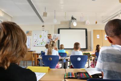 Klassenlehrerin Agnes Schumann erklärt die Aufgabe: Die Bilder markieren, in denen beim Sprechen der Buchstabe „O“ vorkommt
