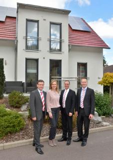 Familie Dawo und Dr. Gerrit Michelfelder vor einem Town & Country Musterhaus: v.l. Benjamin Dawo (Leiter Franchise-Partner-Gewinnung), Gabriele Dawo (Geschäftsführerin), Dr. Gerrit Michelfelder (Geschäftsführer), Foto: Town & Country Haus Lizenzgeber GmbH