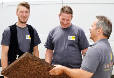 Einweisung auf der Baustelle: INTHERMO-Fachberater Lorenz Stöpfel (rechts) erklärt den beiden Züblin Timber-Fachkräften Kevin Conen (Zimmerergeselle; links) und Michael Stegmair (Holzbau-Vorarbeiter; Mitte) anhand eines Musters die Besonderheiten von Laibungsplatten aus Backkork. Foto: Achim Zielke für INTHERMO, Ober-Ramstadt; www.inthermo.de