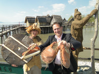 Im Bild links Christoph Schiek vom Pfahlbaumuseum mit der Nachbildung des Steinzeitrades von Olzreute bei Bad Schussenried, rechts Museumsdirektor Dr. Gunter Schöbel mit der Rekonstruktion der 