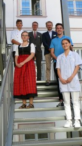 (Claudia Blank) zeigt die drei Auszubildenden Luis Kiebler (oben links), Isabella Bernard (2.v.l.) und Lisa-Marie Sturm (rechts) gemeinsam mit Dr. Stefan Raueiser, Markus Spies und Philipp Semer (v.l.n.r.) anlässlich des Einführungstages in Kloster Irsee
