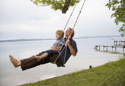 father with son on swing --- Image by © Henglein and SteetsculturaCorbis.jpg