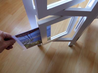 Zwischen zwei dünne Plexiglasscheiben lassen sich Bilder und Werbetexte in 360 Grad drehbaren Rahmen einschieben.