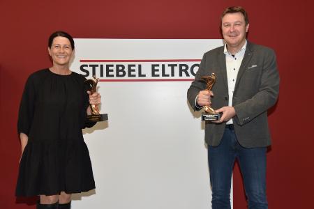 Werbeleiterin Fátima Freitas und Pressesprecher Henning Schulz mit den beiden "Oscars der Baubranche", die STIEBEL ELTRON in diesem Jahr gewinnen konnte in den Kategorien "Regenerative Energien" und "Lüftung und Klimatechnik".