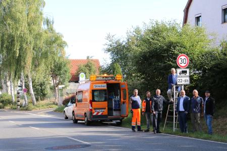Landrat Manfred Görig und Bürgermeister Stephan Paule enthüllten im Beisein von Polizei, Hessen Mobil, Ortsvorsteher und Straßenverkehrsbehörde das 30er-Schild für Nachtfahrten von LKW. Foto: Gaby Richter