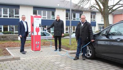 Landrat Manfred Görig (Mitte) probierte gemeinsam mit dem Vorstandsvorsitzenden der Sparkasse Oberhessen, Frank Dehnke (links), sowie dem Leiter des Amtes für Hochbau, Energie und Gebäudewirtschaft, Peter Schwärzel, die neue Ladesäule auf dem Parkplatz des Landratsamts in Lauterbach direkt aus / Foto: Jennifer Sippel / Vogelsbergkreis