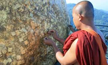 Moench klebt Blattgold auf den Golden Rock Myanmar Homepage.jpg