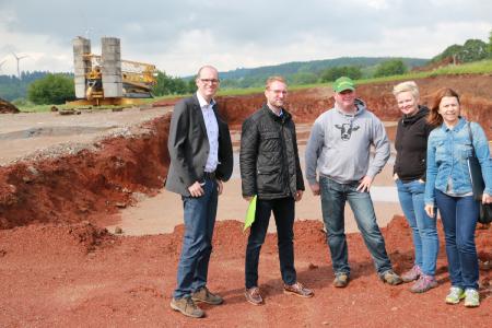 Ehepaar Pöhl hat Großes vor: Die Baugrube im Hintergrund soll bis zum Herbst ein moderner Offenstall werden. Bürgermeister Sascha Spielberger, Wirtschaftsdezernent Dr. Jens Mischak und Amtsleiterin Anja Püchner (v. l.) ließen sich von Jenny und Hans-Joachim Pöhl (2. und 3. v. re.) den Bioland-Betrieb zeigen. Fotos: Gaby Richter