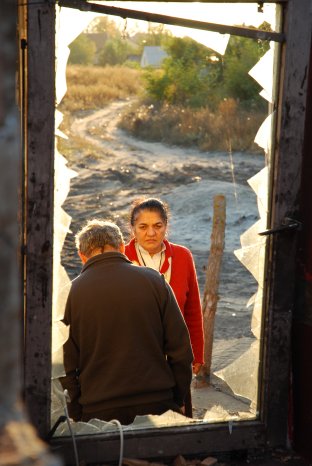 Agnes Daroczi  vor dem zerstörten Haus einer Roma-Familie in Ungarn.jpg