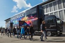 Der InnoTruck des Bundesforschungsministeriums in der Außenansicht mit einer Schülergruppe