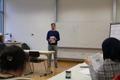 Student Marc Vieweber erklärt elf geflüchteten Frauen die verschiedenen Gütesiegel in Deutschland