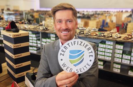 Kay Zimmer, Gründer und Geschäftsführer von schuhplus – Schuhe in Übergrößen -, präsentiert symbolisch das Gütesiegel für seinen Webshop. Neben der Online-Präsenz bietet schuhplus auf über 900 qm ein klassisches Fachgeschäft für große Schuhe am Unternehmenssitz in Dörverden bei Bremen.