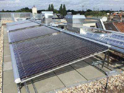 Hochleistungs-Voll-Vakuumröhrenkollektoren auf einem Flachdach mit optimaler Südausrichtung. Die einzeln um 360° drehbaren Röhren lassen sich zusätzlich ausrichten.