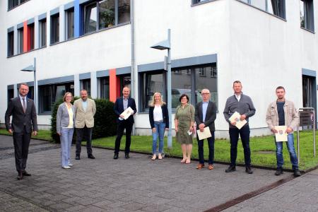 Erster Kreisbeigeordneter Dr. Jens Mischak (links) überreicht die Förderbescheide gemeinsam mit Katharina Barth, Verein Region Vogelsberg (Fünfte von links), und Angelika Boese (Zweite von links), Amt für Wirtschaft und den ländlichen Raum. Volker Repp, Ortsvorsteher von Kölzenhain (von links), Edwin Schneider, Bürgermeister der Stadt Ulrichstein und Beiratsvorsitzender des Vereins Region Vogelsberg, Dagmar Walter-Schneider, Erwin Schneider, Timo Georg, Bürgermeister der Gemeinde Schwalmtal, und Sebastian Volp danken im Rahmen der Übergabe für die Zuwendungsbescheide