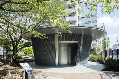 Tado Ando entwarf den ansprechenden Toilettenpavillon im Jingu-Dori Park, Tokio. Die Jedermann-Toilette, die für alt und jung, für Männer und Frauen und für Menschen mit Behinderungen geeingnet ist, bietet mit einer Traufe einen großzügigen Vorraum. Sie befindet sich in der Mitte des Seiteneingangs zum Bahnhof Shibuya